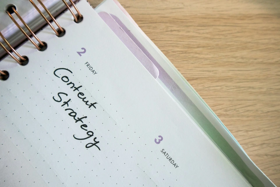 a spiral notebook with a notepad and pen on top of it